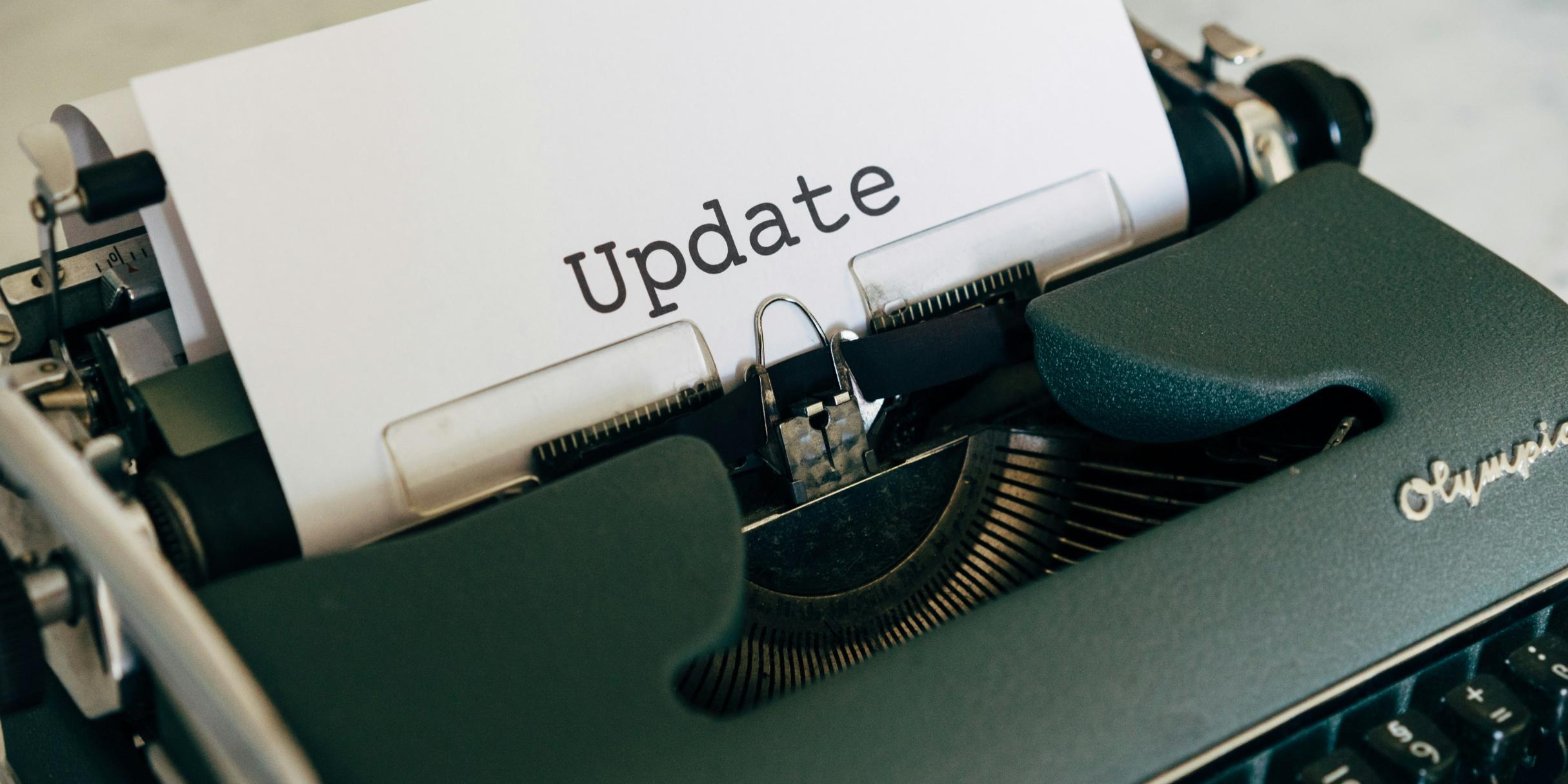 In einer Schreibmaschine steckt ein Zettel, auf dem 'Update' steht