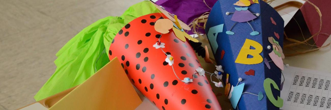 Bunte Schultüten mit Buchstaben und Motiven liegen auf einem Tisch.