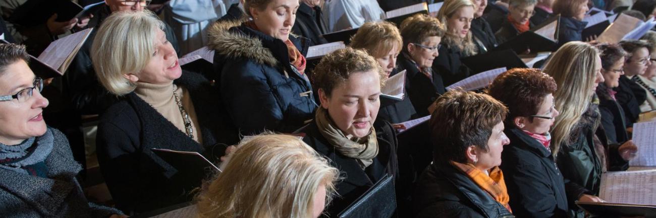 Auf dem Bild ist ein Chor beim Singen zu sehen.
