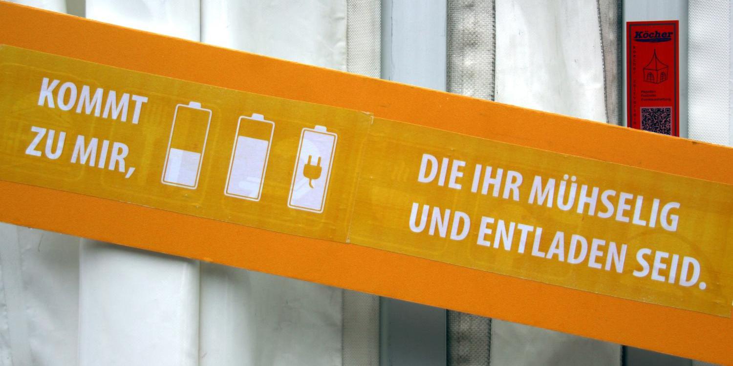 Ein Schild wirbt für eine Handy-Ladestation
