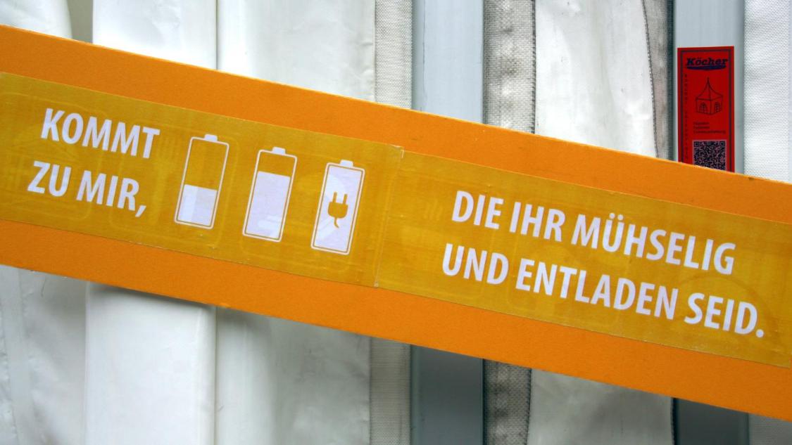 Ein Schild wirbt für eine Handy-Ladestation
