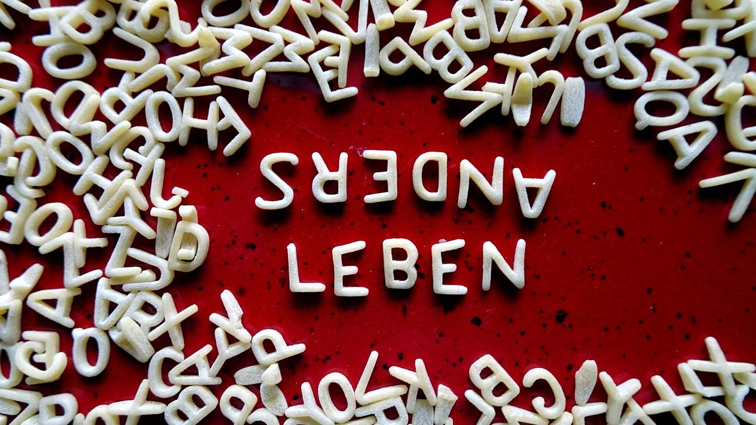 Buchstabennudeln bilden die Worte 'Anders leben'