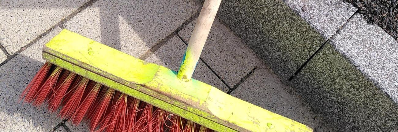 Ein Besen lehnt an einer Mauer