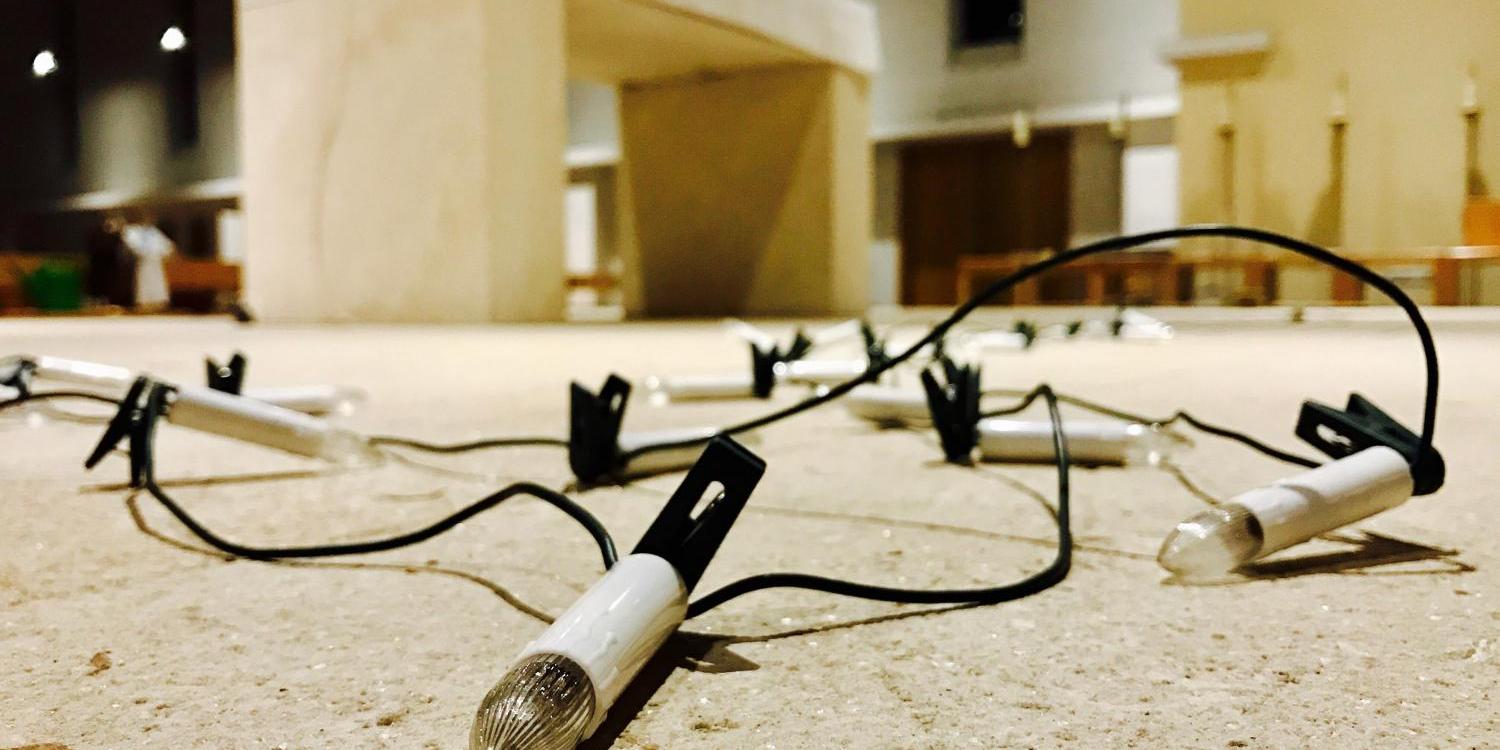 Eine Lichterkette liegt vor einem Altar (c) Bild: Michael Beck In: Pfarrbriefservice.de Eine Lichterkette liegt vor einem Altar