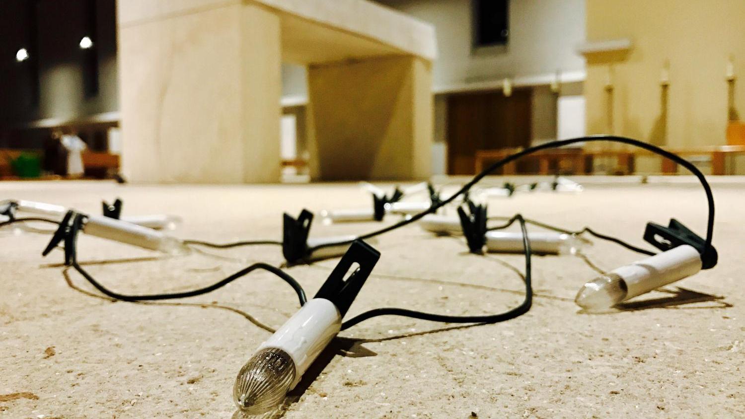 Eine Lichterkette liegt vor einem Altar