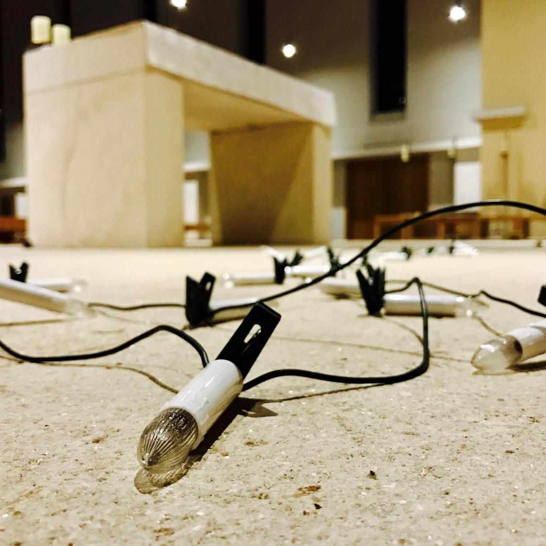 Eine Lichterkette liegt vor einem Altar