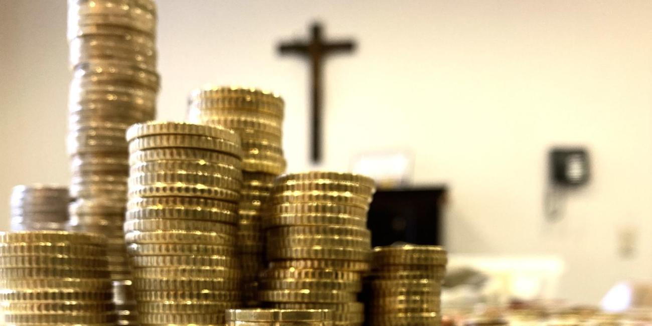 img_5710_0_by_Sylvio_Krueger_pfarrbriefservice (c) Bild: Sylvio Krüger In: Pfarrbriefservice.de Gestapelte Münzen. Im Hintergrund sieht man ein Kreuz an der Wand.