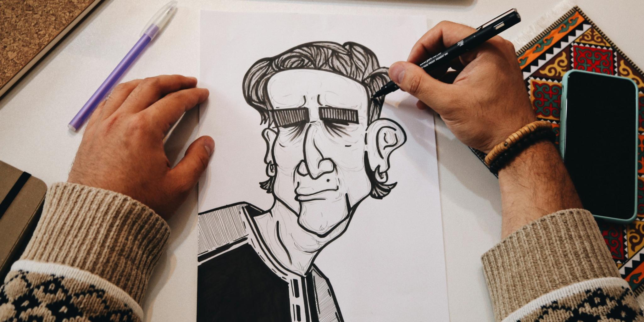 Zwei Hände zeichnen eine Karikatur auf ein Blatt Papier