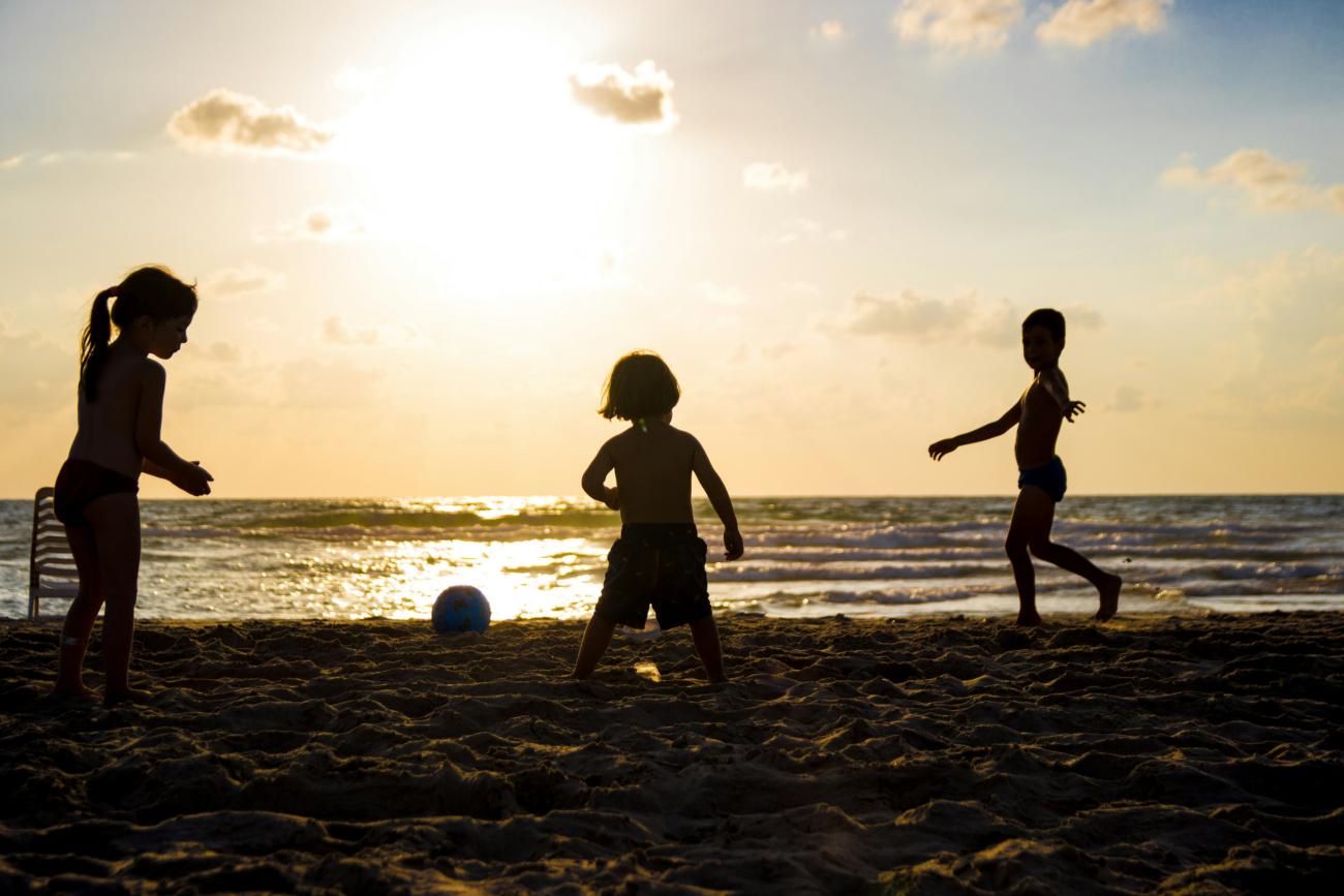Silhouette von drei Kindern am Strand