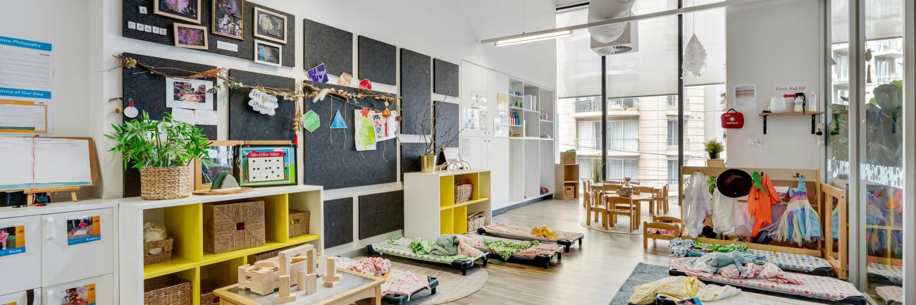 Ein Raum eines Kindergartens mit vielen Möbeln und vielen Fenster.