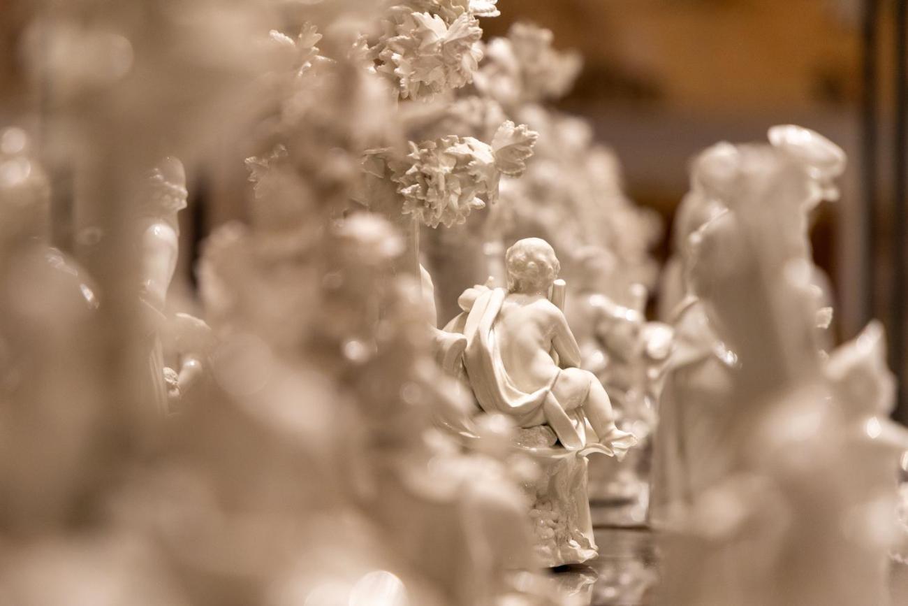 Barocke Tischdekoration aus weißem Porzellan mit zahlreichen kleinen Figuren, ausgestellt in einer Glasvitrine im Museum für angewandte Kunst, Wien.