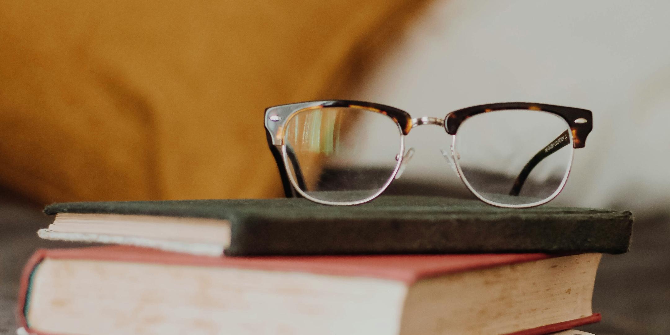 Brille auf Stapel von drei Büchern