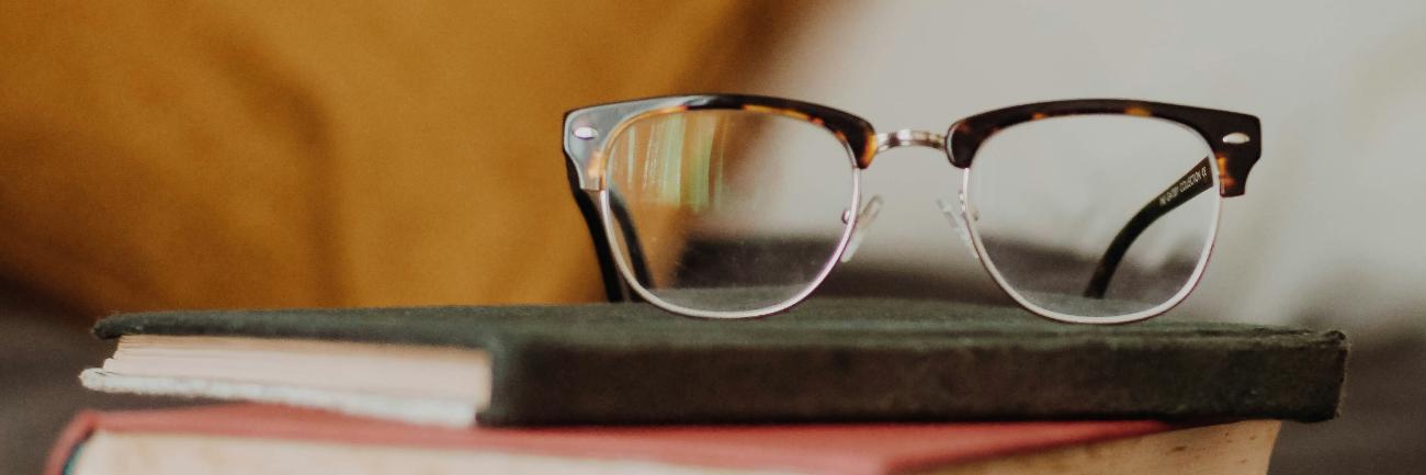 Brille auf Stapel von drei Büchern