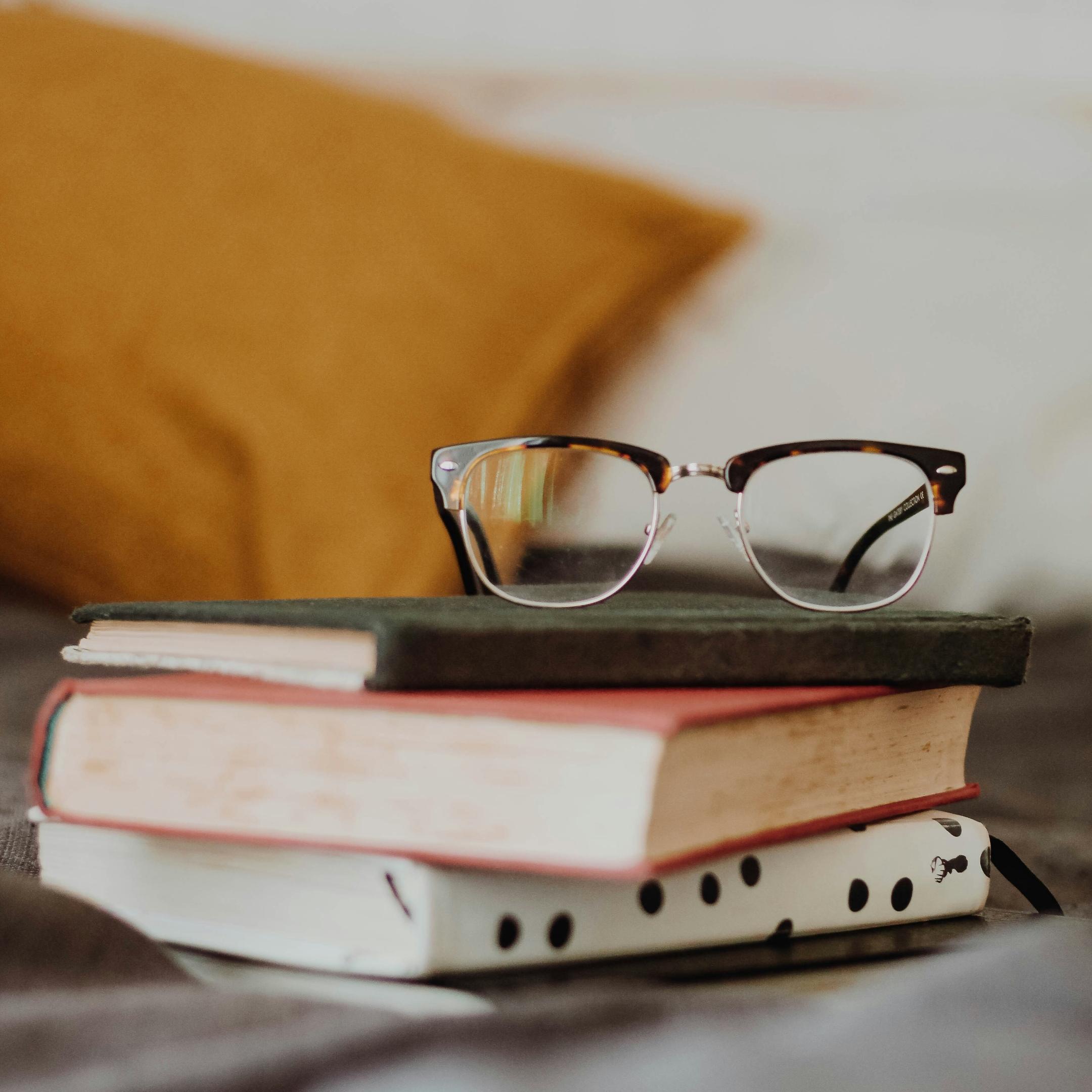 Brille auf Stapel von drei Büchern