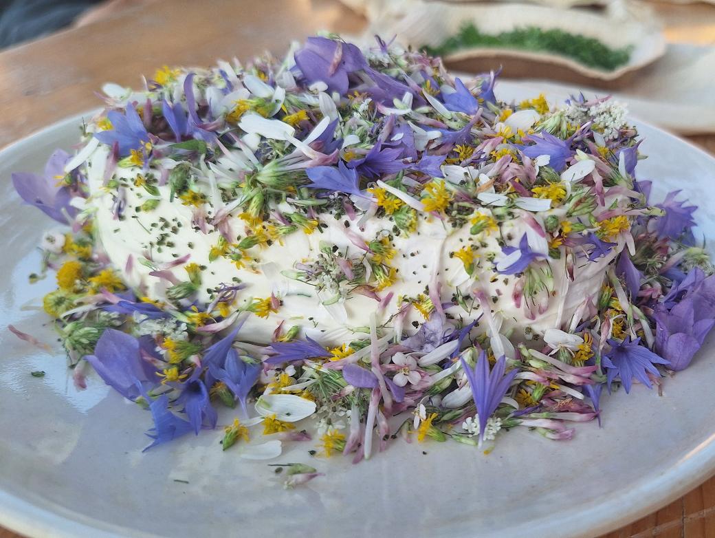 Mit Blüten von Wildblumen dekorierter Camembert
