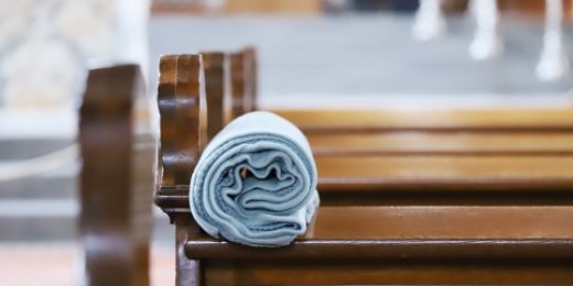 Kirchenbank mit aufgerollter Decke