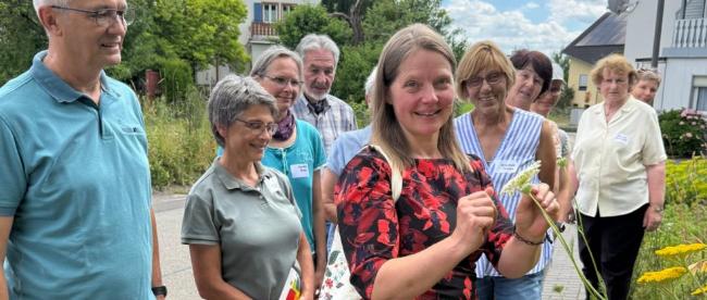 Referentin Annette Fehrholz (Mitte) stellt den Teilnehmenden Pflanzflächen in Föhren vor.
