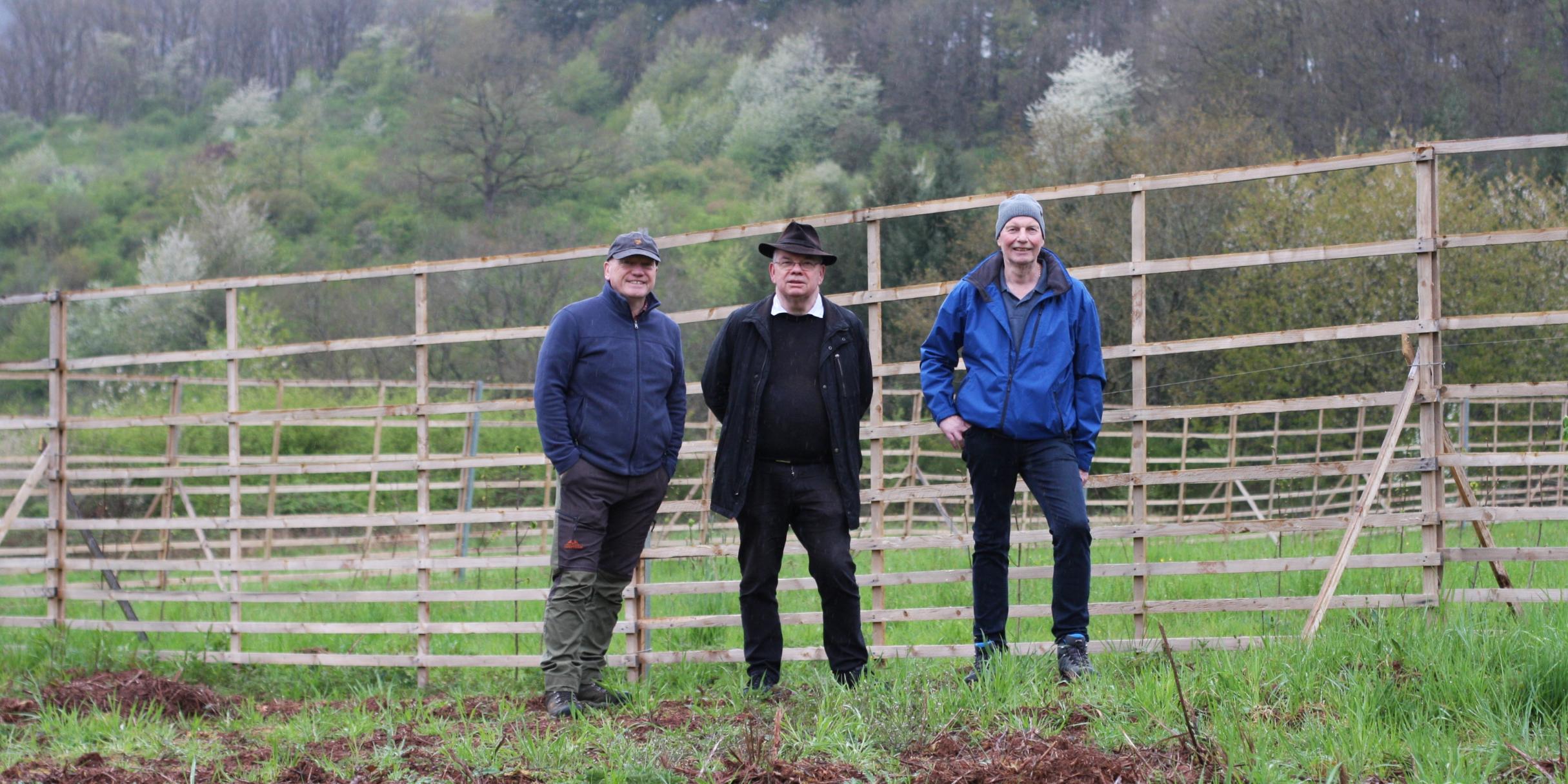 Bernhard Pütz, Pfarrer Georg Goeres und Peter Brosius vor dem Hordengatter