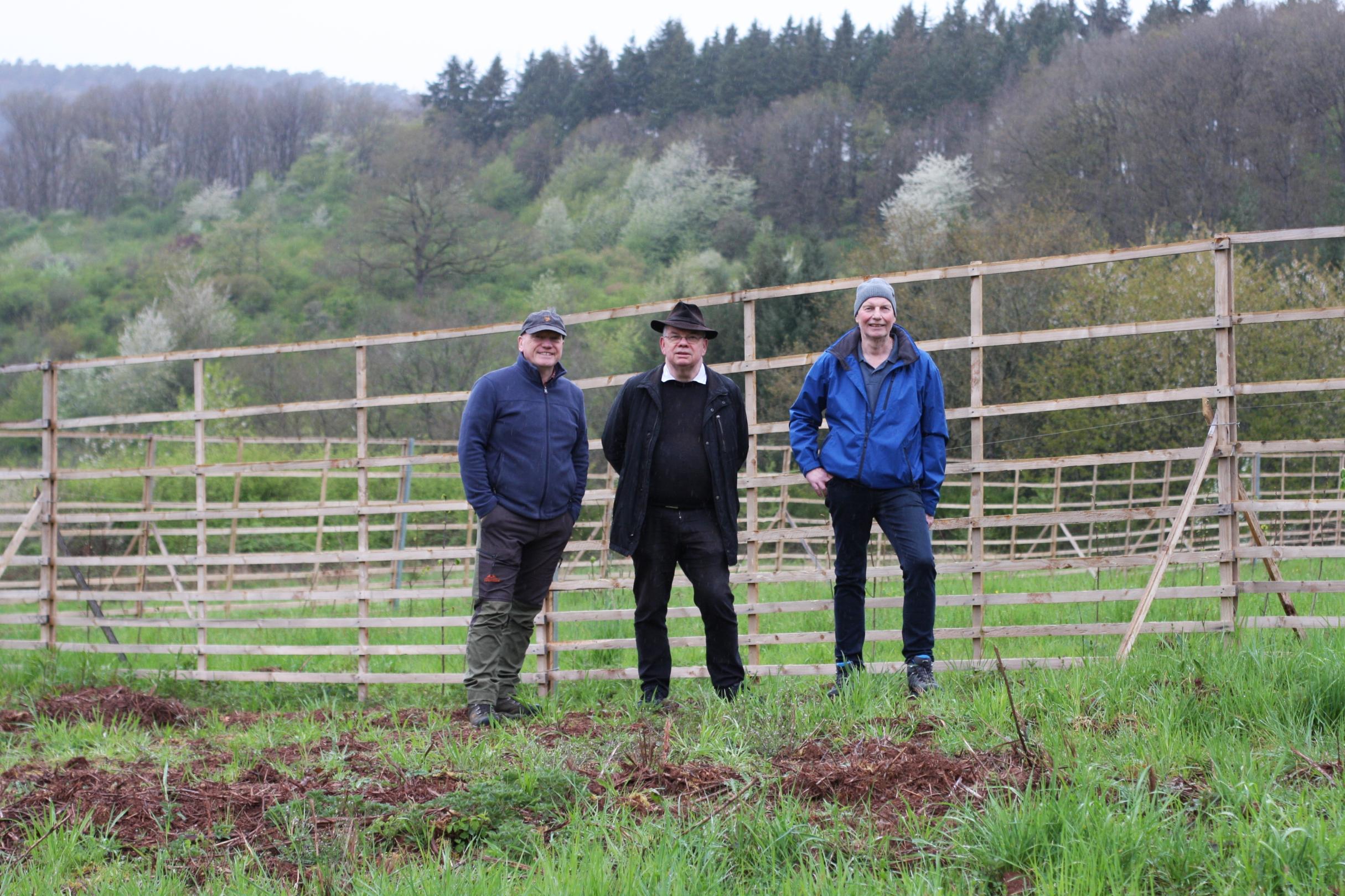 Bernhard Pütz, Pfarrer Georg Goeres und Peter Brosius vor dem Hordengatter