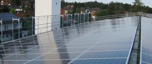 Solarpanele vor einem Kirchturm