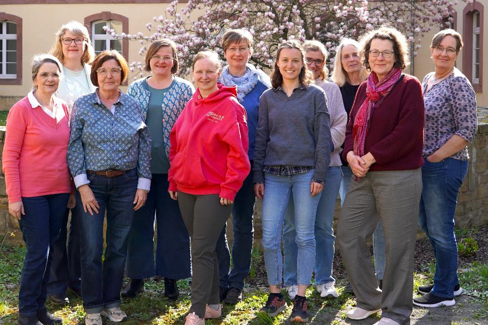 11 Frauen unterschiedlichen Alters stehen für ein Gruppenbild zusammen
