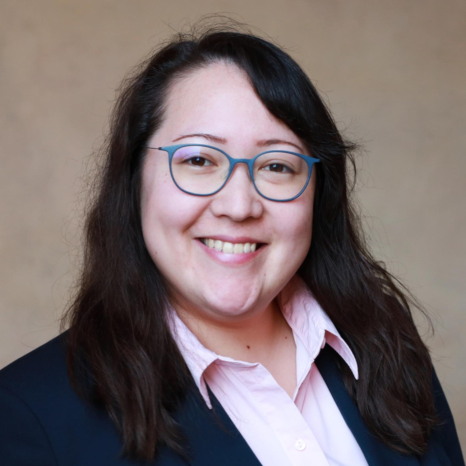 Eine Frau mit Blazer und Brille
