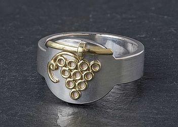 Hier ist der Ring von Weihbischof Gebert abgebildet. Er ist silberfarbig und breit und hat die Umrisse von einem Strunk Trauben  in der Mitte.