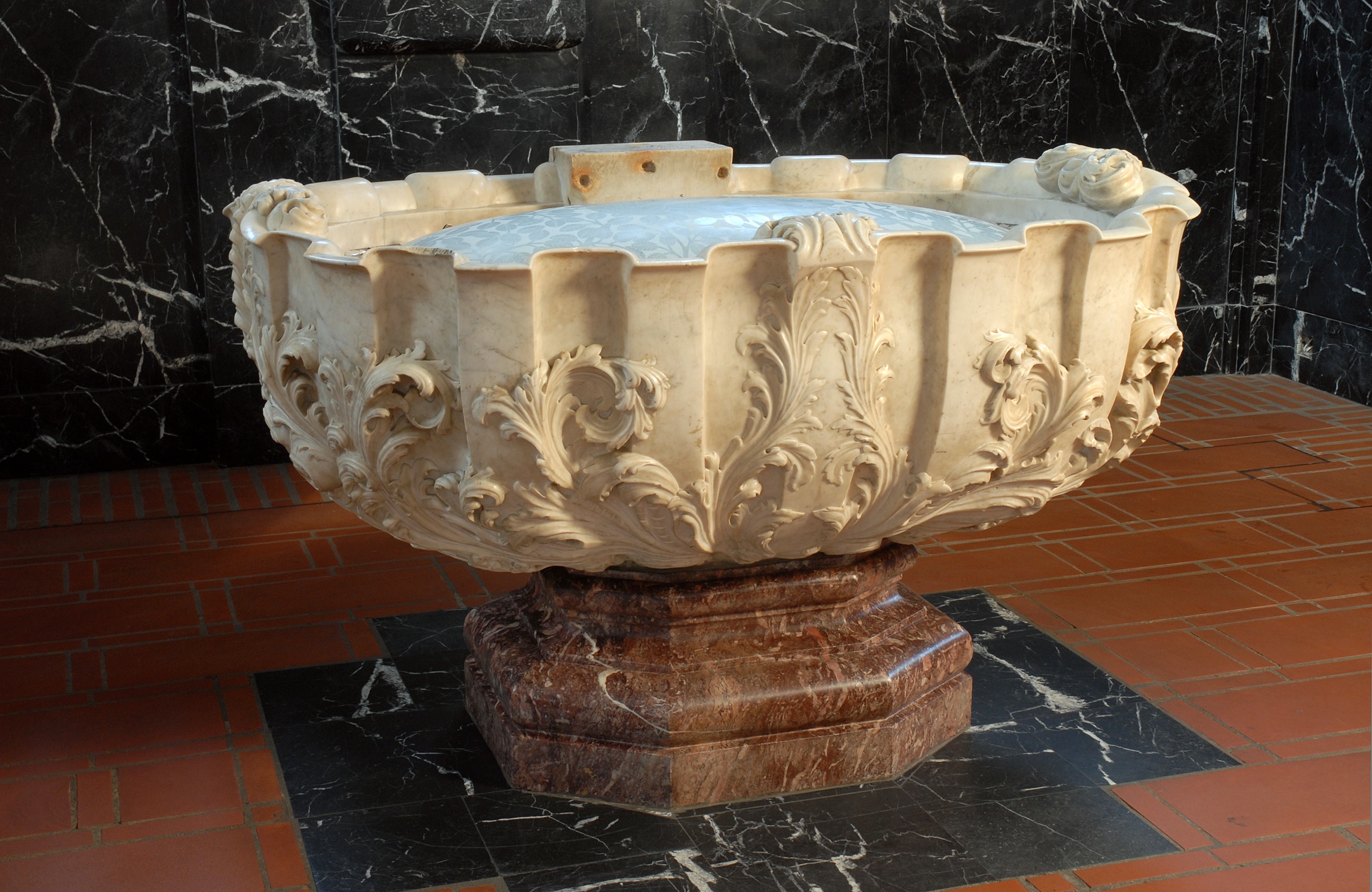 Hier ist das Taufbecken des Trierer Doms zusehen. Er ist schlicht gehalten und aus hellem Stein gefertigt