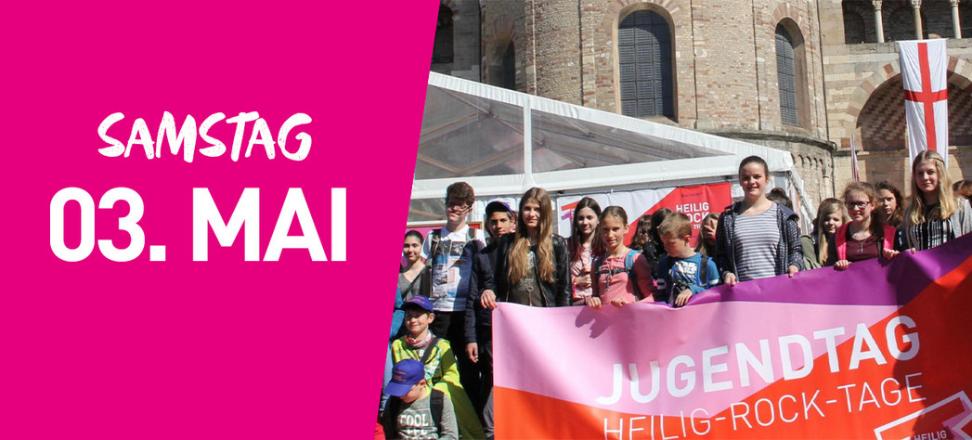 Eine Gruppe junger Menschen steht mit einem großen Banner vor dem Trierer Dom. Auf dem Banner steht Jugendtag. Links im Bild steht auf pinkfarbenem Hintergrund Samstag dritter Mai