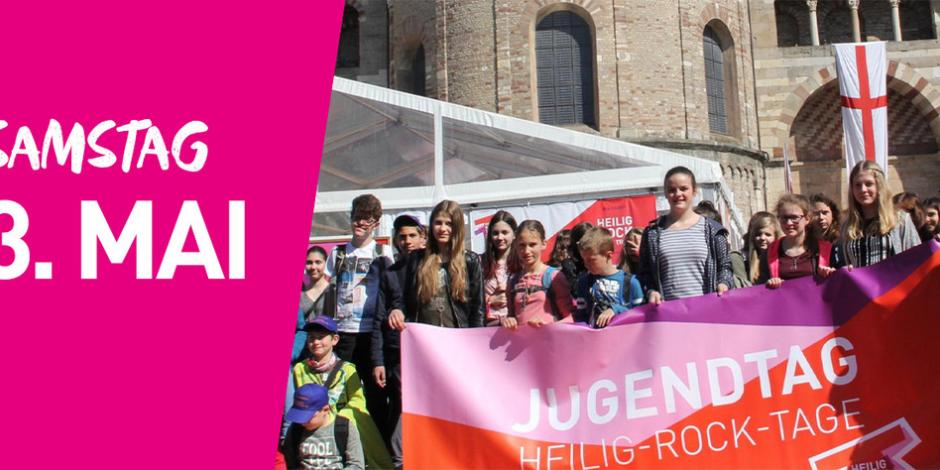 Eine Gruppe junger Menschen steht mit einem großen Banner vor dem Trierer Dom. Auf dem Banner steht Jugendtag. Links im Bild steht auf pinkfarbenem Hintergrund Samstag dritter Mai