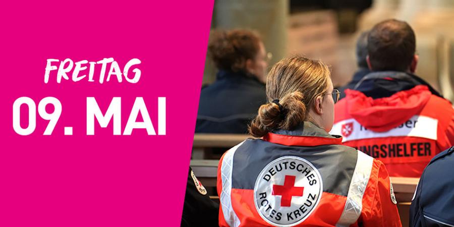 In einem Gottesdienst sitzen Menschen mit Uniformen des roten Kreuzes und der Feuerwehr. Links im Bild steht auf pinkfarbenem Hintergrund Freitag neunter Mai